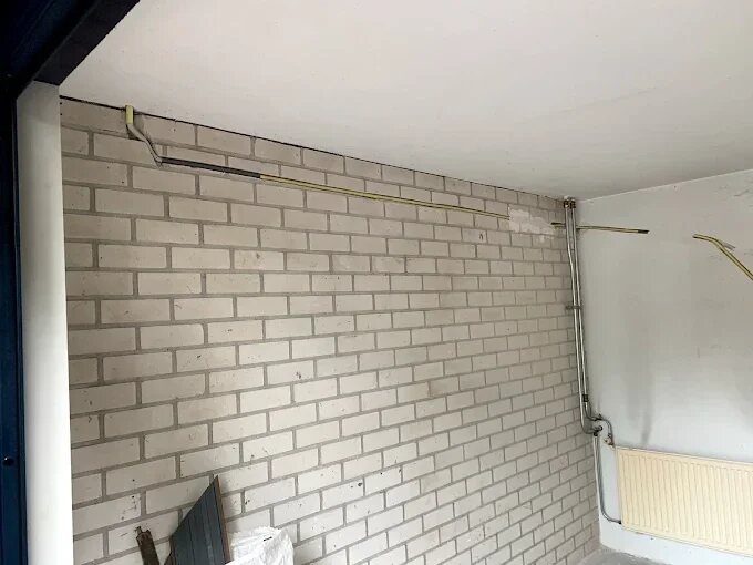 Leidingen en aansluitpunten op een stenen wand